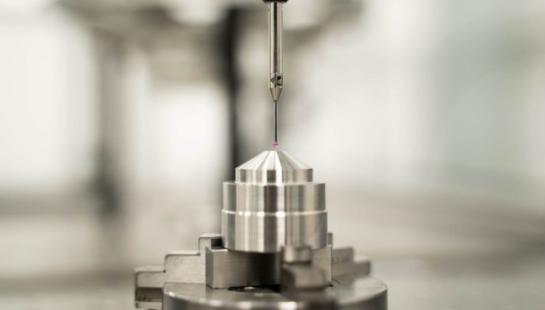 Inspection probe with ruby-tipped stylus measuring a turned metal component in a lathe chuck
